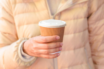 Close-up of woman holding eco-friendly cup of coffee to go, street coffee, zero waste