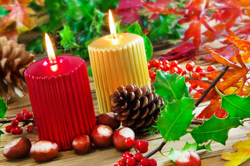 Dekoration im Herbst und zwei Kerzen auf Holz