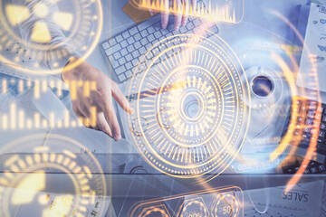 Double exposure of man's hands typing over computer keyboard and tech theme hologram drawing. Top view. Technology concept.