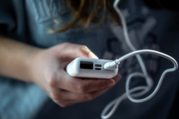 Close-up of a white power bank in a female hand.
