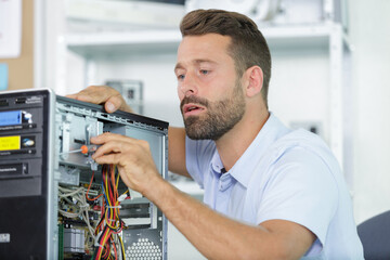 Fototapeta na wymiar male worker fixing a computer plugin