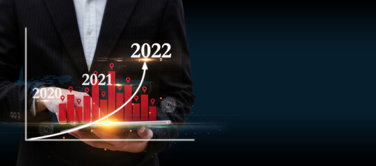 businessman using digital mobile tablet with graphic candle stick population chart hologram on dark background, population community growth, stock market, investment and financial business concept