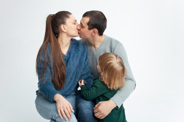 happy family isolates on a white background, smiling, hugging, kissing. Concept, lifestyle. mom and dad kissing