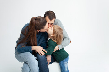 happy family isolates on a white background, smiling, hugging, kissing. Concept, lifestyle. mom, dad, son