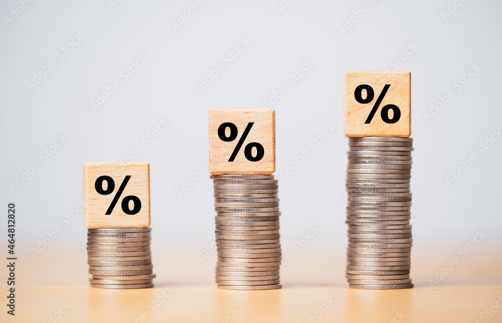 Poster percentage sign print screen on wooden cube block which lay down on increasing coins stacking for in