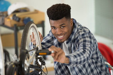 young male mechanic working on bicycle