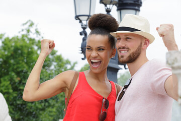 Obraz premium young couple making victory gesture with clenched fist