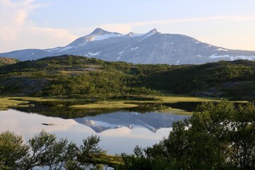 A mountain in the distance reflecting in a small lake in northern Norway 
