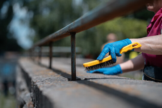 Volunteer Worker Painting And Renovate Railing Or Fence In Public Park