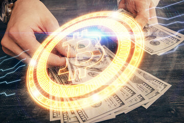 Multi exposure of blockchain theme drawing hologram and USA dollars bills and man hands. Business...