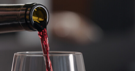 pour red wine into wineglass closeup indoor shot