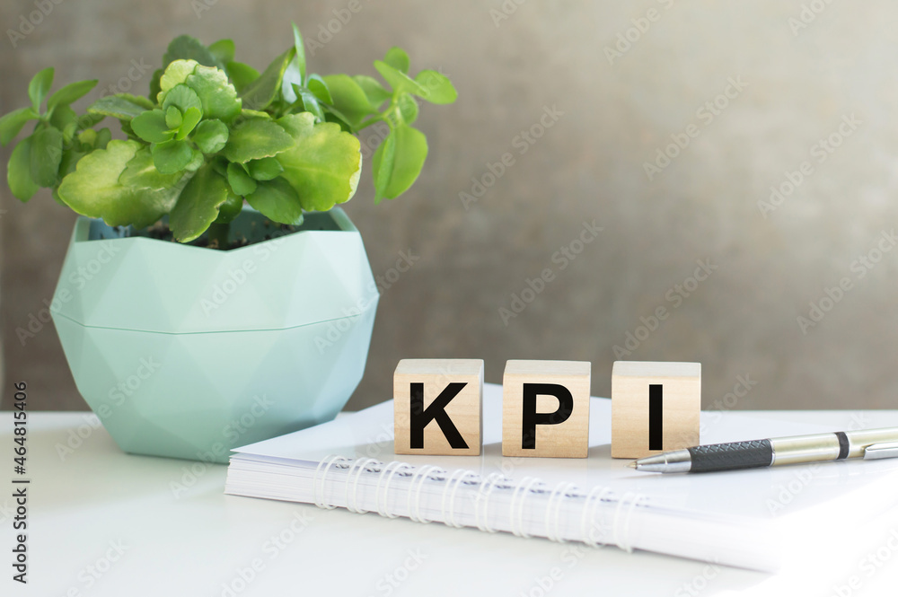 Poster text kpi on wood blocks next to houseplant. key performance indicator, kpi concept.
