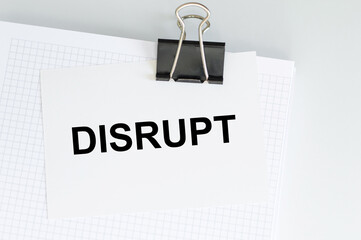 disrupt text on white paper on clip attached to blonkot on table