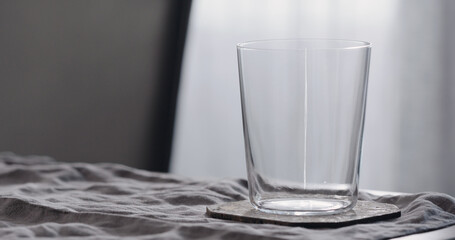 empty tumbler glass on linen cloth