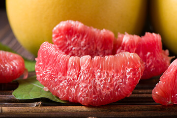 close up of peeled red pomelo fruit  on wood background