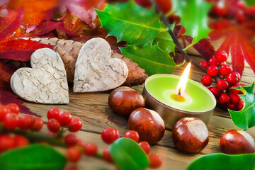 Dekoration im Herbst mit zwei Herzen und Kerze mit Kastanien