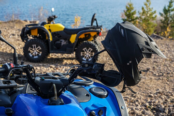 black helmet on the handlebars of a motorcycle against the background of an ATV, lake and autumn...