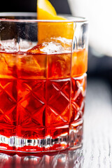 Ready-made bright red cocktail with citrus in an old fashion glass