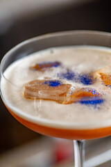 Ready orange cocktail with glitter foam on the bar