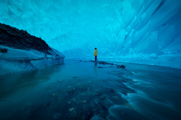 A man stand alone in ice cave at Mandenhall Glacier in Juneau, Alaska