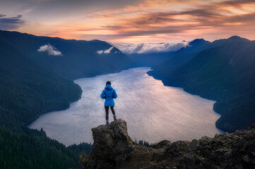 Hiker overlooking sunset from viewpoint of Mount Storm King, Olympic National Park, Washington