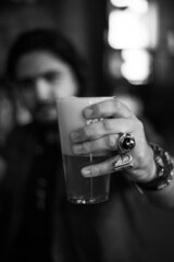 man holding a glass of beer in a bar