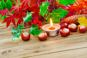Dekoration im Herbst und Kerze auf Holz