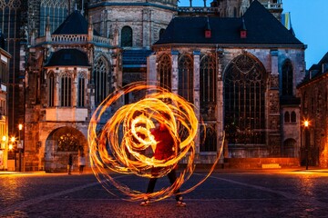fire spinner creating shapes in front of cathedral