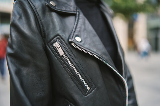 Woman leather jacket design concept on hanger holding. Woman in black leather jacket. 