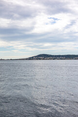 Vue par temps nuageux sur Sète et le Mont Saint-Clair, sur bord de l’Étang de Thau, depuis les parcs à huîtres (Occitanie, France)