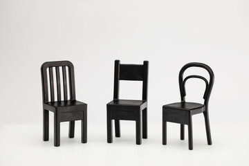 Fototapeta premium Three black chairs on a white background