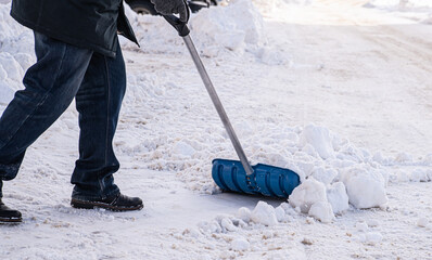 a man cleans a shovel exit for his car in the parking lot