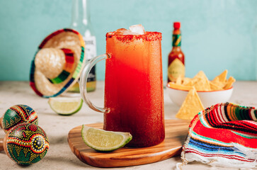 Michelada - Mexican alcoholic cocktail with beer, lime juice, tomato juice, spicy sauce and spices