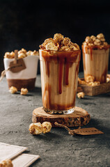 Banana milkshake with caramel and popcorn on a dark background. Selective focus