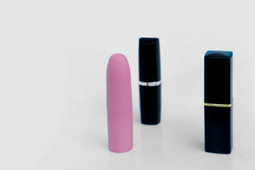 set, 3 pieces of lipstick in closed cases on white isolated background, red, raspberry, pink, coral, peach color, close-up, the concept of decorative cosmetics