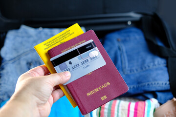 close-up of things, documents are stacked in a black open suitcase on the couch, concept of summer vacation, business trip, go on a long-awaited voyage