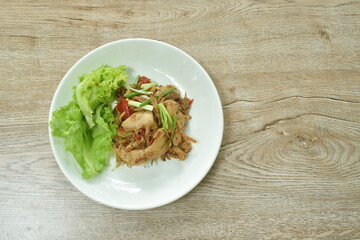 spicy fried roasted chicken meat with chili dressing slice spring onion with lettuce on plate