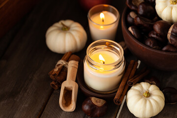 Obraz na płótnie Canvas Autumn composition with aromatic candle, cinnamon, pumpkin. Old books, knitted vintage napkin as decor