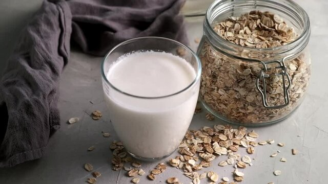Oat Milk in the glass. Circular motion oat milk and bottle. Vegan concept.