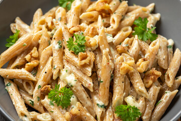 Whole Wheat Penne pasta with gorgonzola cheese sauce, spinach and walnut. Healthy food.