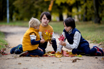 Happy family, mother with children, having their autumn pictures taken in the park