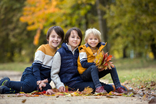 Happy family, funny children, having their autumn pictures taken in the park, playing