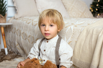Child siting on bed, boho style, smiling, cute toddler with smart casual style