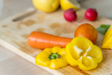 Healthy living and Vegan food. Cooking vegan food. Ingredients fruits and vegetables on the chopping board. Bell peppers, carrots, tomatoes.