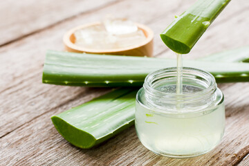 Aloe vera plant and aloe gel on wooden table background.