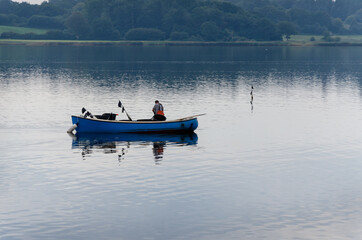 Fisherman fishing out to river in his small fishing boat