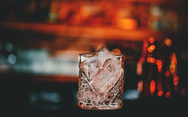 Ice cube in an empty glass on a bar counterin bar or pub