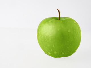 A perfect fresh green apple isolated on a white background in full depth of field with an edged trajectory.