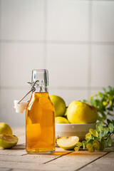 Healthy organic food. Apple cider or vinegar in a glass bottle and fresh apples on a light background.