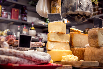 Italian food market with cheese and pepperoni, formaggio crociato fresco, Tuscan delicatessen stall...